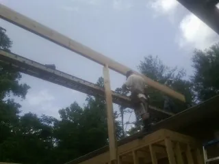 Carpenter setting a ridge beam over a new addition frame — Ice Dam Removal by Roofing Brothers in Saint Paris